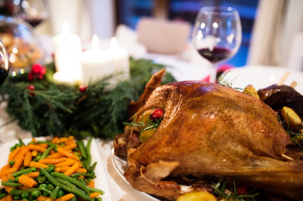 Christmas meal laid on table in decorated dining room.