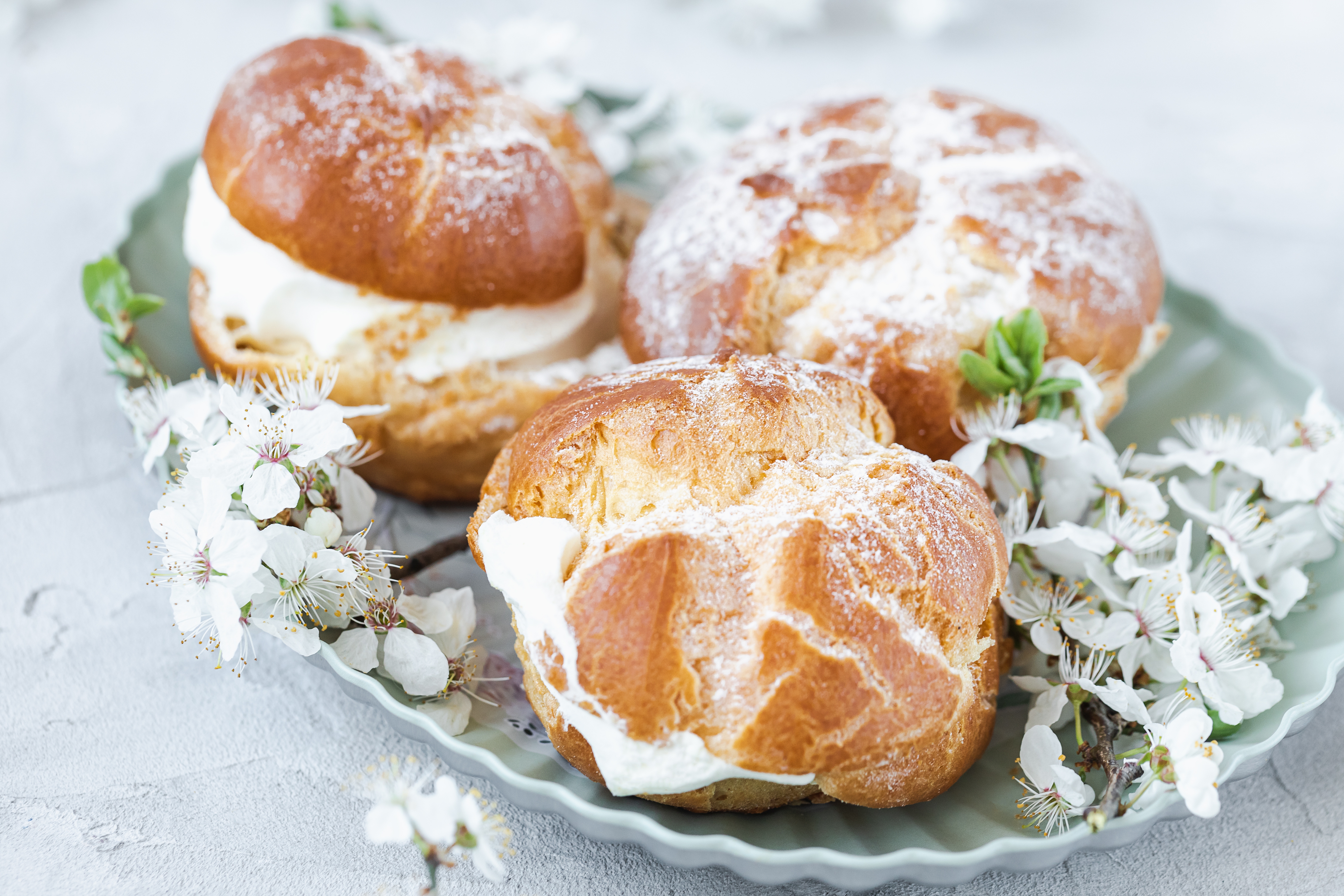 Choux Buns with whipped cream and sugar powder on top. Choux pastry dessert. French cream puffs