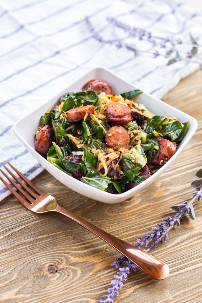 White ceramic bowl filled with sausage keto salad.